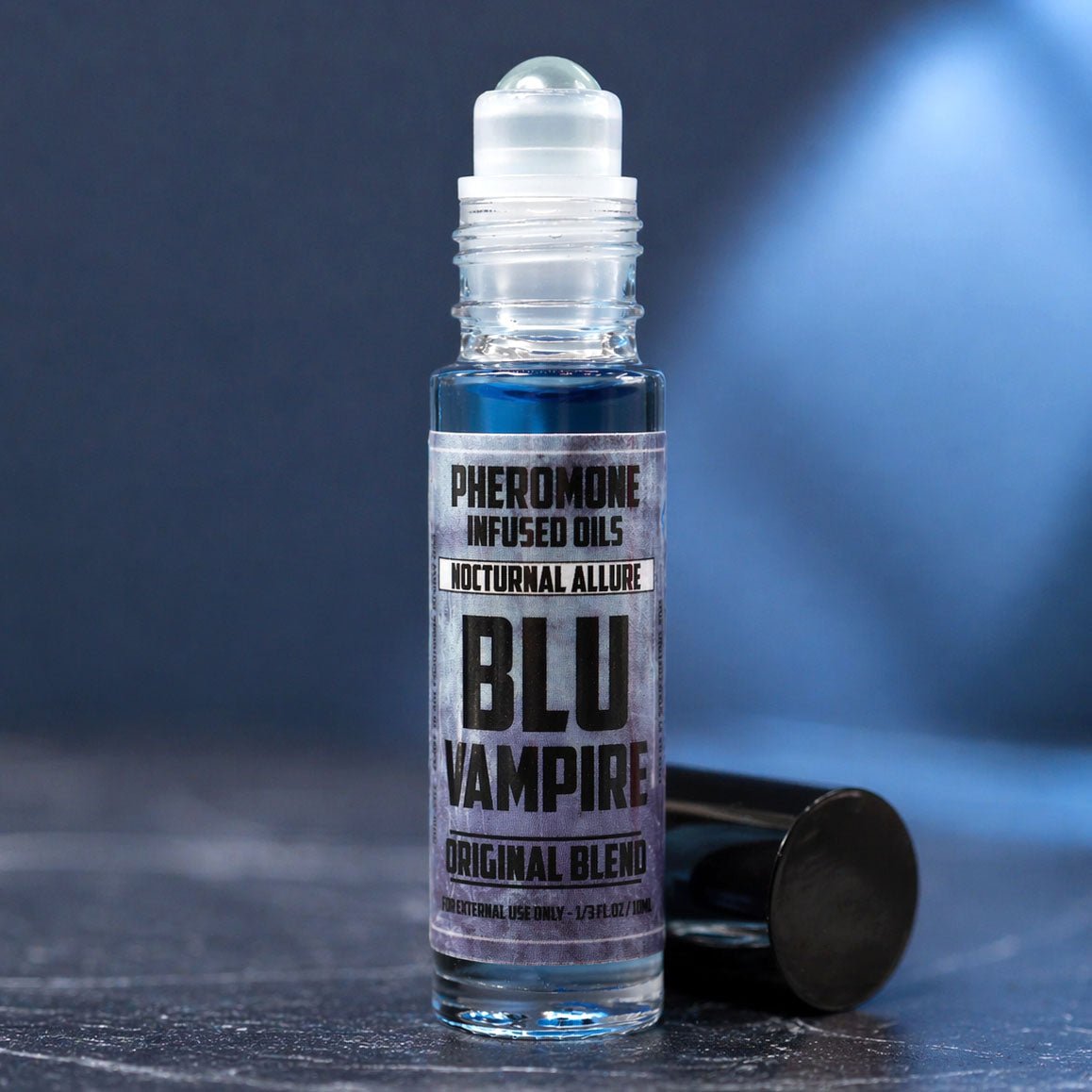 Roll-on bottle of BLU Vampire Pheromone Infused Oils on a dark background
