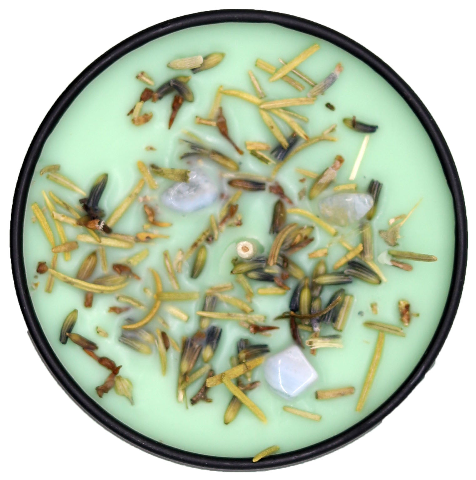 Candle with dried herbs and flowers on a light green background