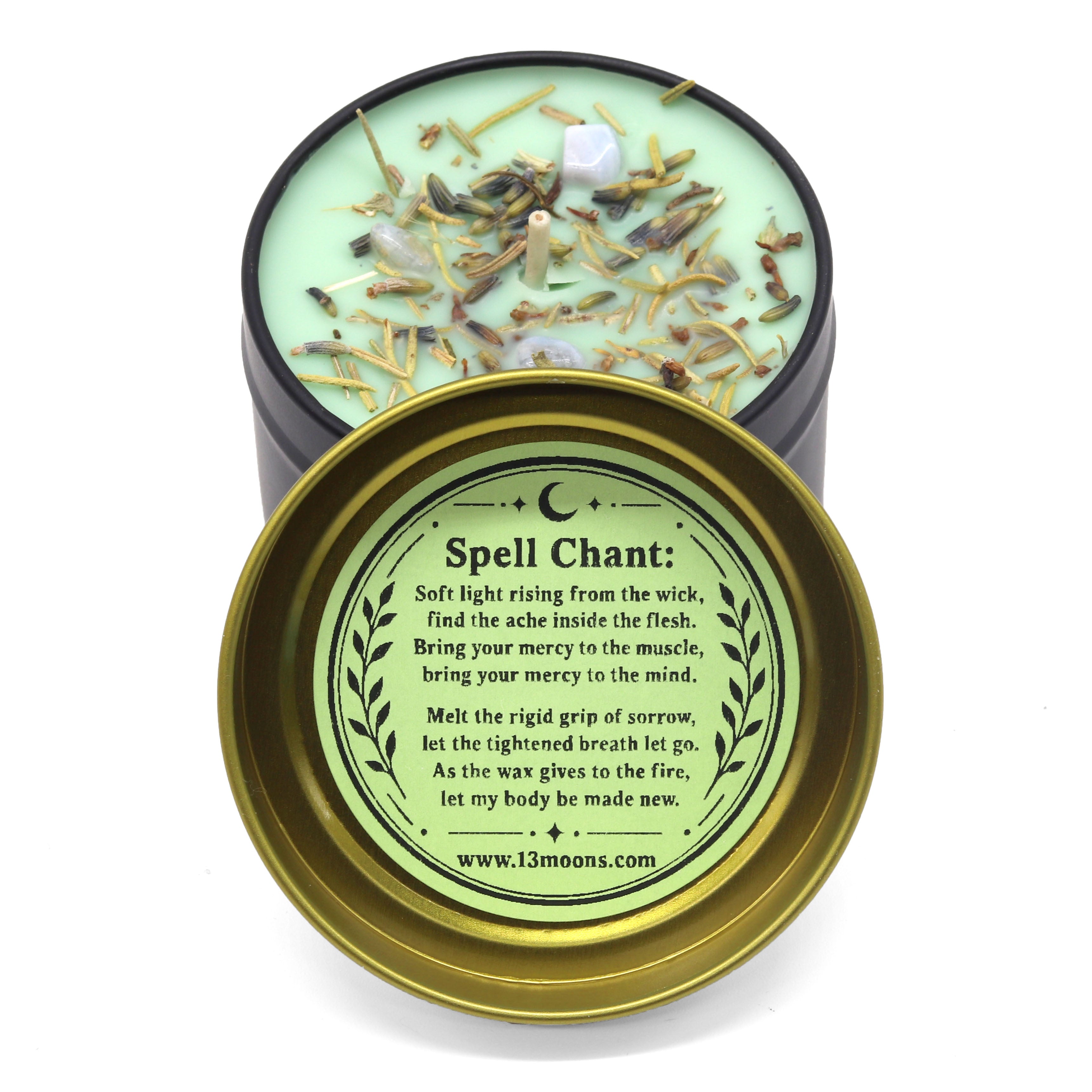 Candle with decorative elements and a gold lid featuring text and a website URL.